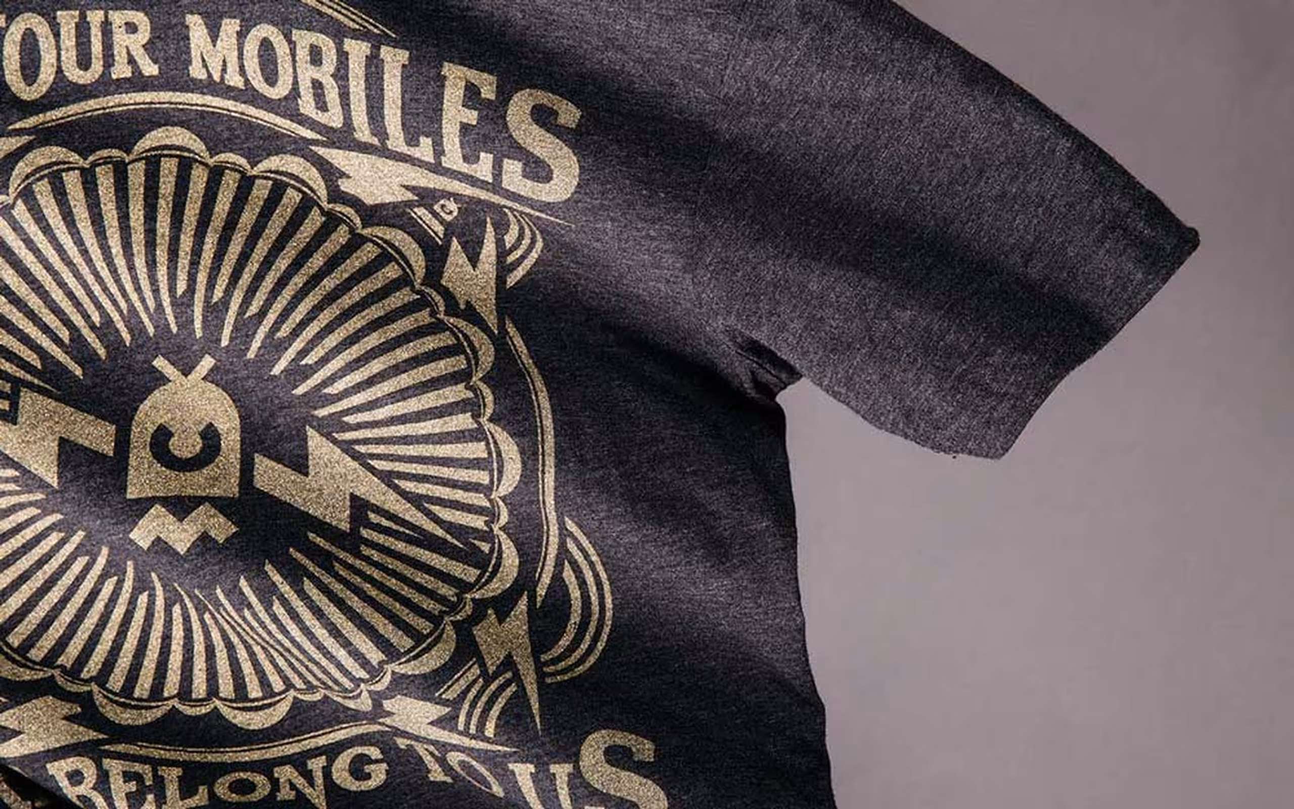 A black heathered shirt with a gold metallic design