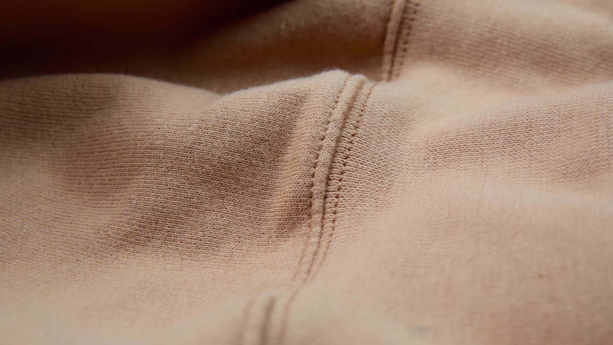 close up on a hoodies seam that is tan