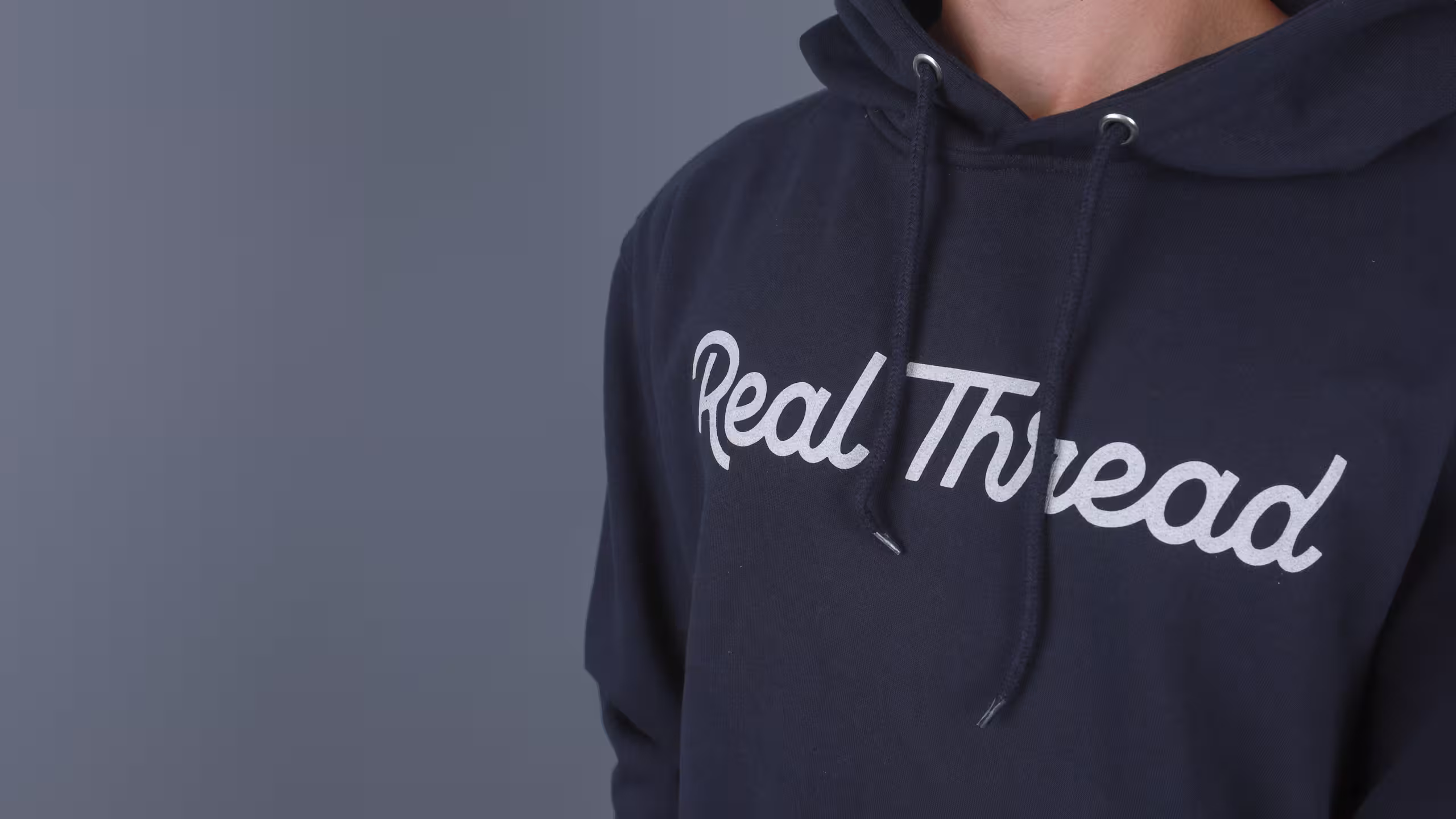 close up of a navy hoodie with the real thread logo
