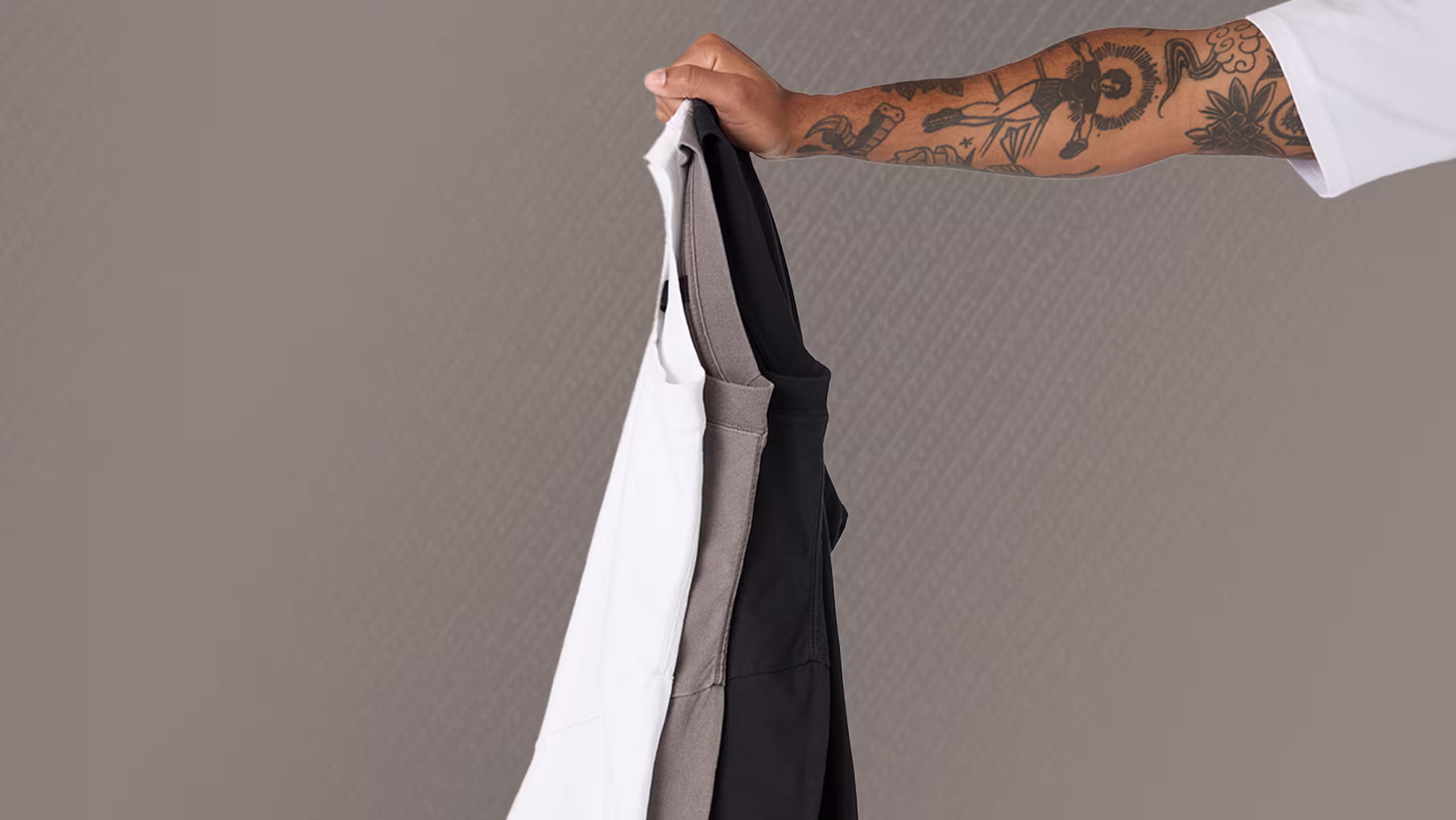 someone holding three t-shirts
