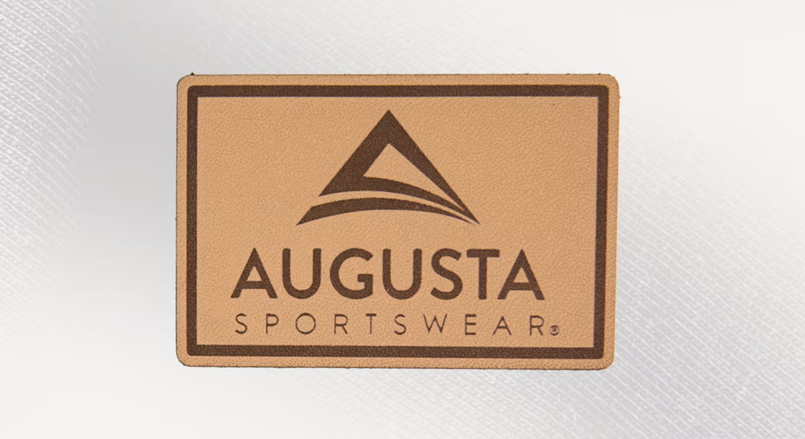 a rectangle natural leather patch with the words augusta sportswear