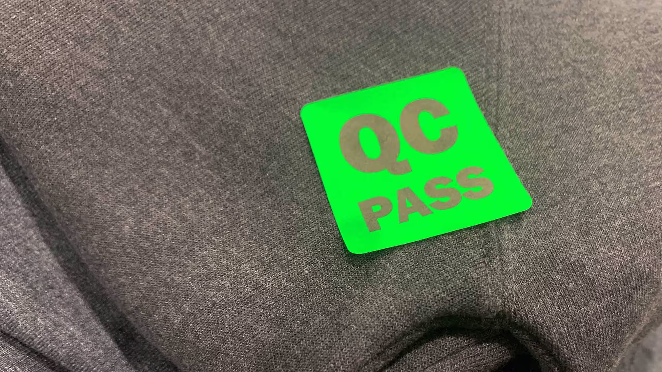 close up of a QC pass sticker on sweatshirt