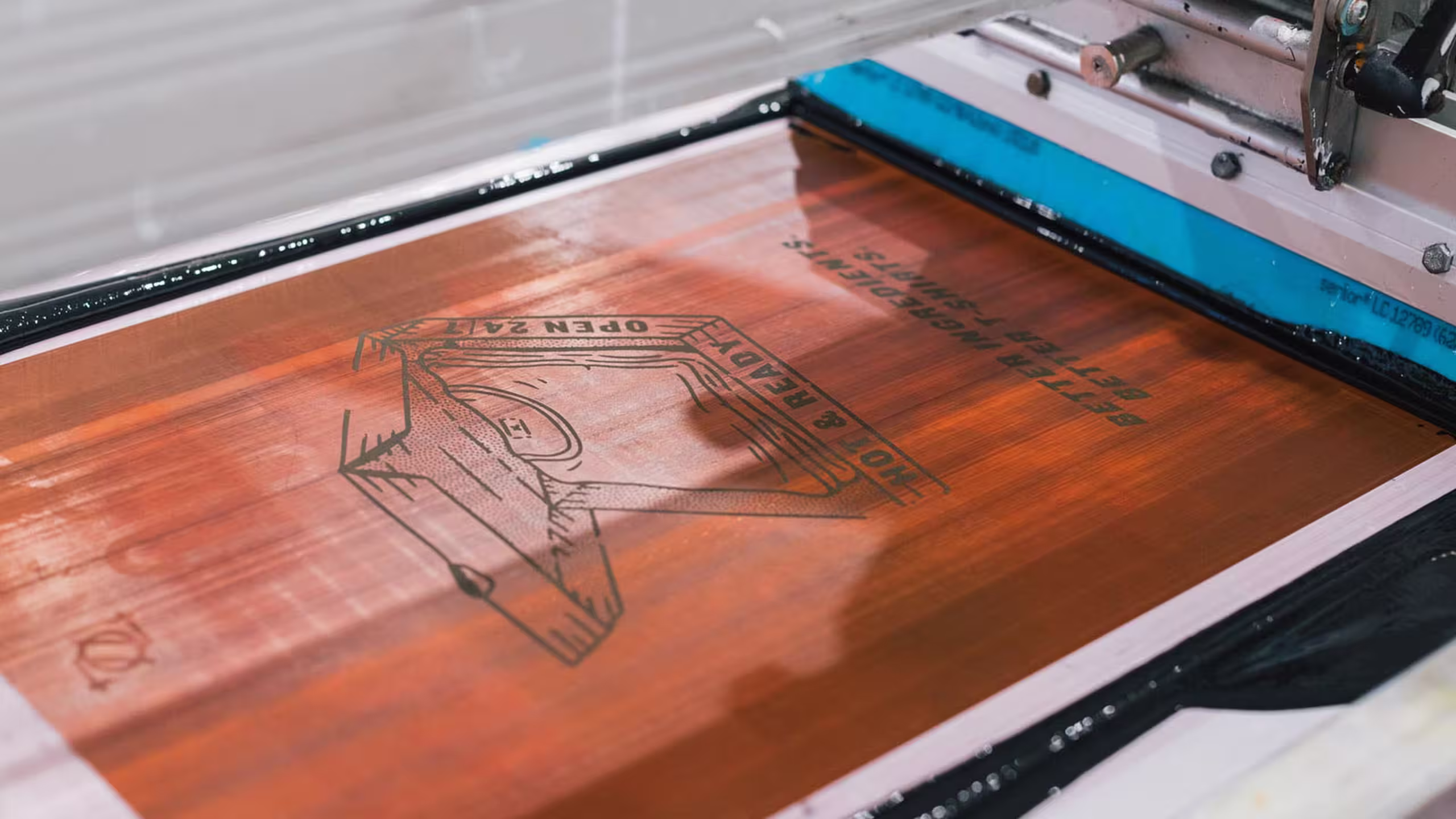 close up view of a screen printer with black ink on the screen